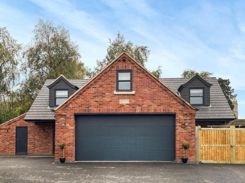 a brick house with a garage at Tilia Loft in Scotter