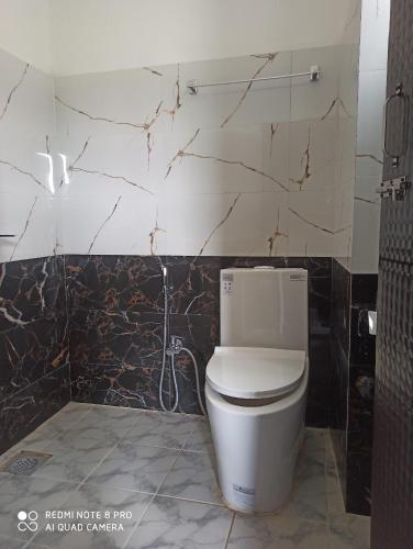 a bathroom with a white toilet in a room at Hotel namo buddha in Sauraha