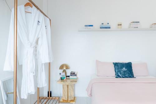 a white bedroom with a bed and a mirror at Bintana Sa Paraiso in Mambajao