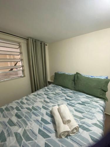 Un dormitorio con una cama con toallas. en Ao lado do Hospital Calixto excelente localização, en Itabuna