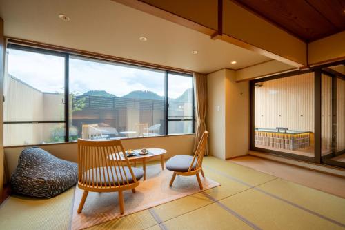 Una habitación con una mesa y una silla y una ventana grande. en Takinoyu Hotel, en Tendō