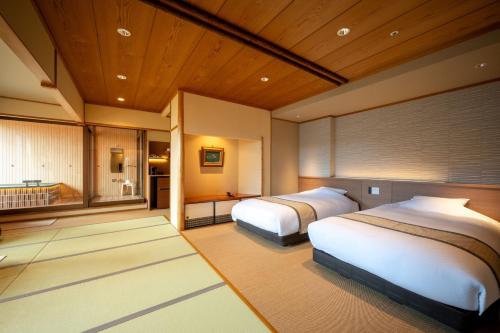 Un dormitorio con dos camas y un baño. en Takinoyu Hotel, en Tendō