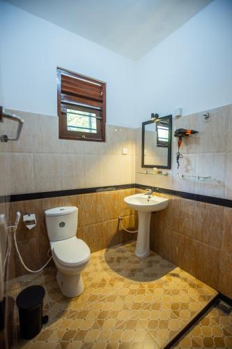 a bathroom with a toilet and a sink at Lira Unawatuna in Unawatuna