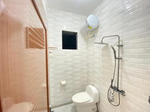 a white bathroom with a shower and a toilet at Fatmara Villa Full House in Kejajar