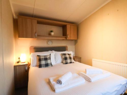 een slaapkamer met een bed met twee handdoeken erop bij Swift Cabin in Staintondale