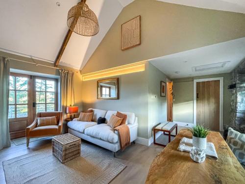 een woonkamer met een bank en een tafel bij Night Sky Cottage in Kielder