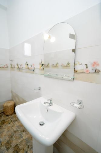 a bathroom with a white sink and a mirror at Scenery River Star Hotel in Hikkaduwa