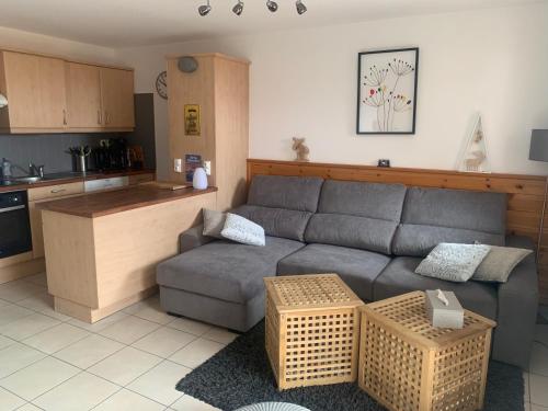 a living room with a couch and a kitchen at Très bel appartement pied de pistes 6 pers Serre Chevalier Chantemerle in Saint-Chaffrey