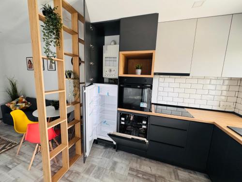 a kitchen with black and white cabinets and a red chair at Popoveni Garden Vila in Craiova