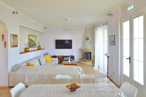 a white living room with a bed and a fireplace at Tzitzi Pistachio Villa in Khlóï