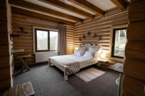 a bedroom with a bed in a log cabin at LAVANDA hotel club in Slavske