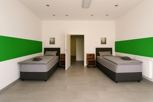 Livemore24 - Apartment 2 in Herten 24-7 Check-In في هيرتين: سريرين في غرفة بجدران خضراء وبيضاء