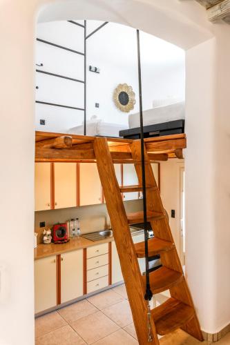 a ladder leading up to a kitchen with a loft at Aurora Mykonos Villas in Kalafatis