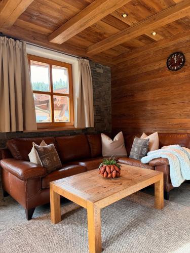 a living room with a leather couch and a coffee table at Kitzbühel Garten Suite in Kitzbühel