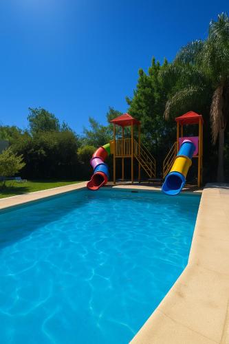 a swimming pool with two slides and a playground at Complejo STC SomoS in Colón