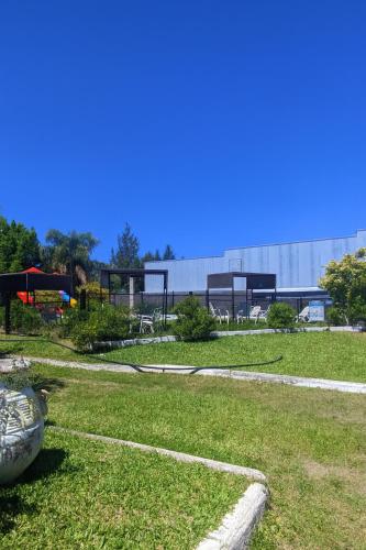a field of grass with a building in the background at Complejo STC SomoS in Colón