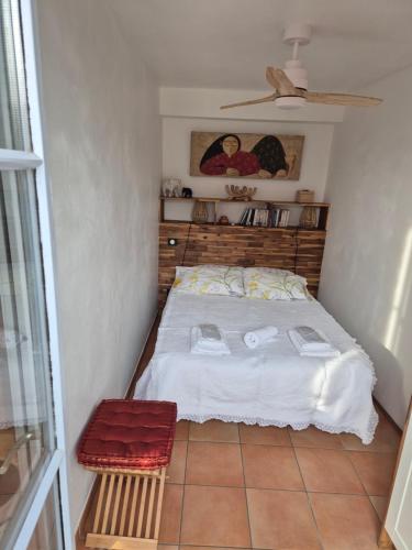 een kleine slaapkamer met een bed met witte lakens bij Appartement Syrah in Collioure