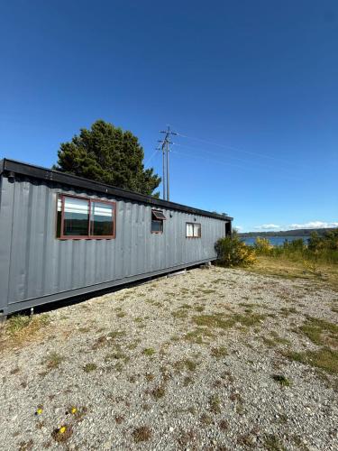 un edificio de metal encima de un campo en Refugio Zarapito View of the Pudeto River, en Pudeto
