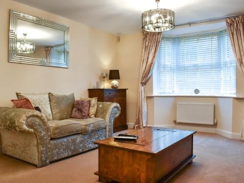 Song Bird Holiday Home في ويتبي: غرفة معيشة مع أريكة وطاولة قهوة