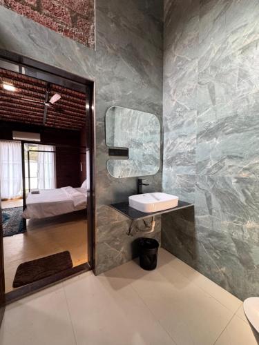 a bathroom with a sink and a mirror at NOSSA GOA VILLA in MUMBAI GORAI in Mumbai