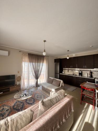 een woonkamer met twee banken en een keuken bij Zoe's Luxury Homes in Alexandroupoli