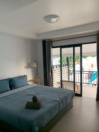 a bedroom with a large bed and a balcony at Mook tawan Beach house in Ko Mook