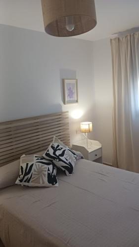 a bedroom with a bed with a pillow and a lamp at casa andaluza 109 in Novo Sancti Petri