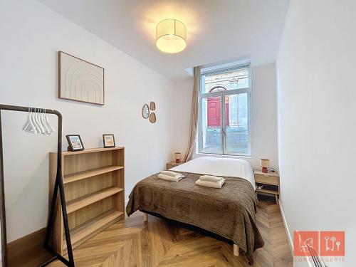 a small bedroom with a bed and a window at Le Parvis - Vieille ville - proche plage et port in Boulogne-sur-Mer