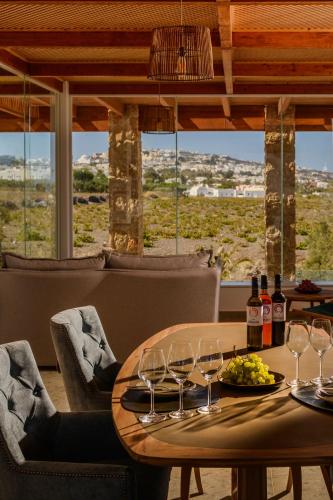 a table with wine glasses and a plate of grapes at Safrani Suites in Fira