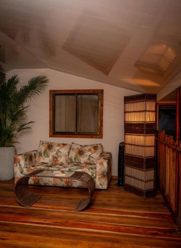 a living room with a couch and a book shelf at La Pérgola lodge in Sarapiquí