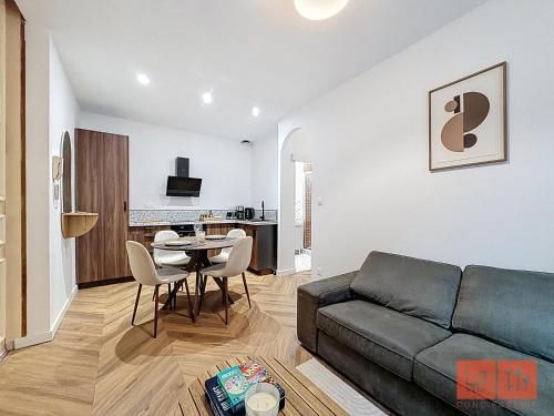 a living room with a couch and a table at Le Parvis - Vieille ville - proche plage et port in Boulogne-sur-Mer