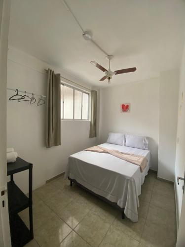 a bedroom with a bed and a ceiling fan at Ao lado do Hospital Calixto apartamento térreo in Itabuna