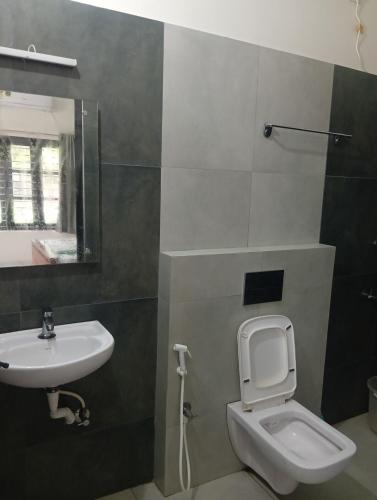 a bathroom with a toilet and a sink at Mini Meadow in Neyyāttinkara
