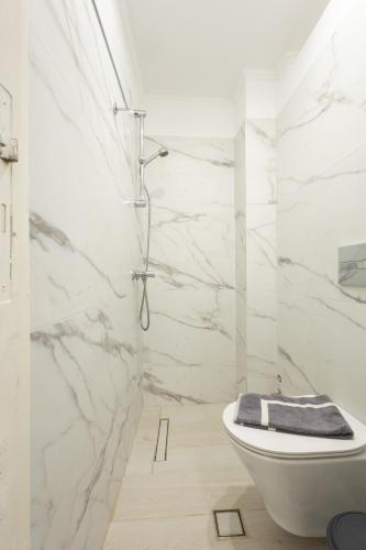 a white bathroom with a toilet and a shower at Archontiko Hotel in Kalymnos
