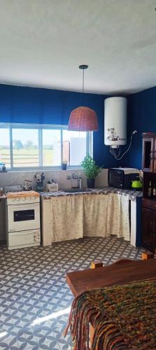a kitchen with blue walls and a sink and a table at AZUL Casa De Campo in Esquina