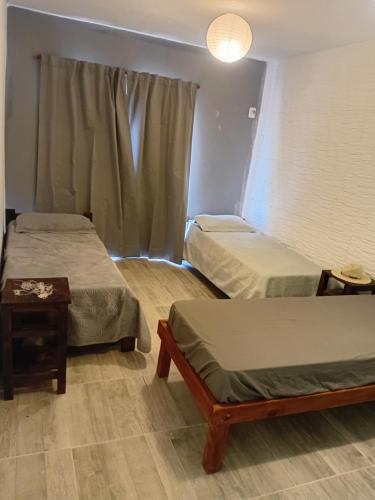 una stanza con due letti, un tavolo e una finestra di AZUL Casa De Campo a Esquina