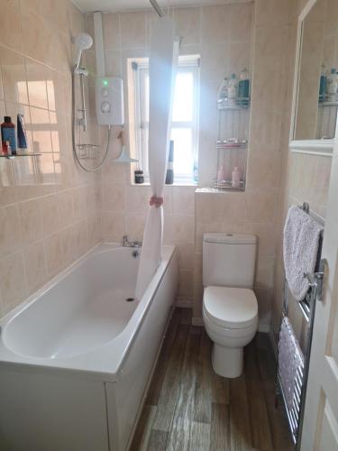 ein Badezimmer mit einer weißen Badewanne und einem WC in der Unterkunft Gorgeous Sandpiper Mews in Worcester