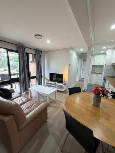 a living room with a couch and a table at Cozy 2BR apartment, Woden,Canberra , pet free, free parking in Lyons