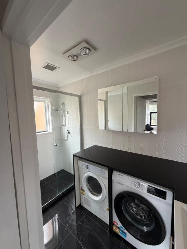 a laundry room with a washing machine in it at Cozy 2BR apartment, Woden,Canberra , pet free, free parking in Lyons