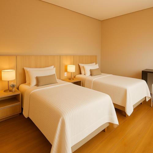a hotel room with two beds and two lamps at MK Flat - A 2 quadras do mar in Matinhos