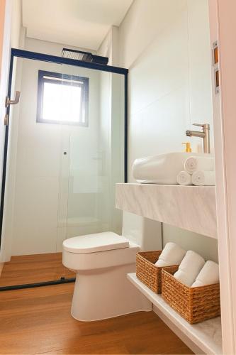 a bathroom with a toilet and a sink at MK Flat - A 2 quadras do mar in Matinhos
