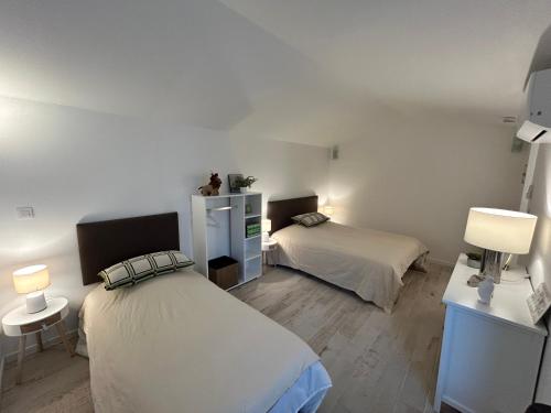 a bedroom with two beds and two lamps in it at Jolie maison de vacances proche du centre et de la mer in Saint-Raphaël