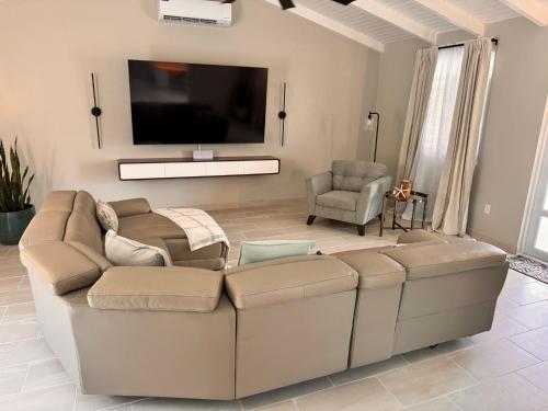 Una televisión o centro de entretenimiento en Zion's Oasis, Pristine three Bedroom House