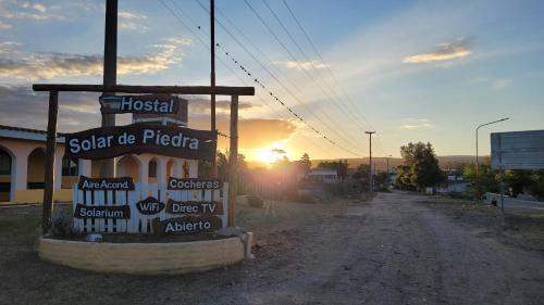 a sign on a dirt road with the sunset in the background at Solar de Piedra in Tanti