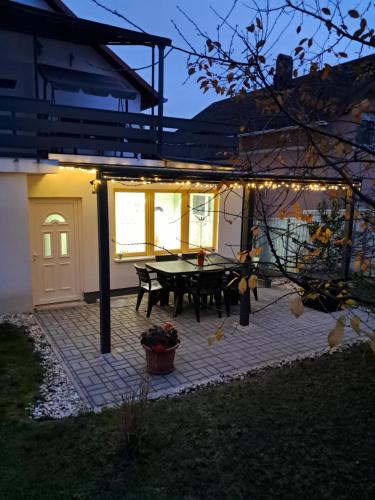 a patio with a table and lights on it at Igali Varázs Apartman 150 méter a fürdőtől in Igal