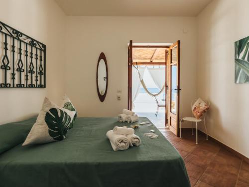 a bedroom with a green bed with towels on it at Salina Castel Vinci in Rinella