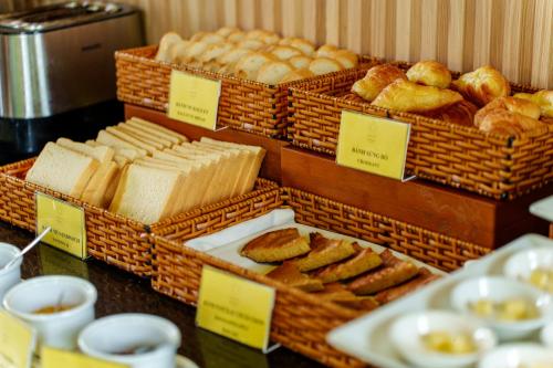 eine Präsentation von Brot und Gebäck in Körben auf einem Tisch in der Unterkunft Gia Huy Riverside Hotel Hoi An in Hoi An
