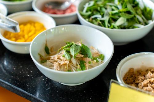 eine Gruppe von Schüsseln mit Lebensmitteln auf einem Tisch in der Unterkunft Gia Huy Riverside Hotel Hoi An in Hoi An
