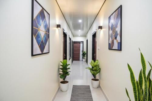 un corridoio con piante in vaso sulle pareti di FabHotel Rajdhani a Kānpur
