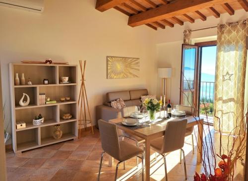 ein Wohnzimmer mit Tisch und Couch in der Unterkunft Casa Vacanze La Perla del Lago in Passignano sul Trasimeno